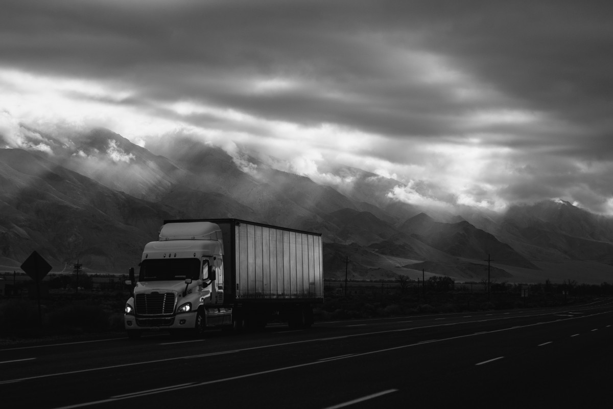 camion sue route de montagne noir et blanc